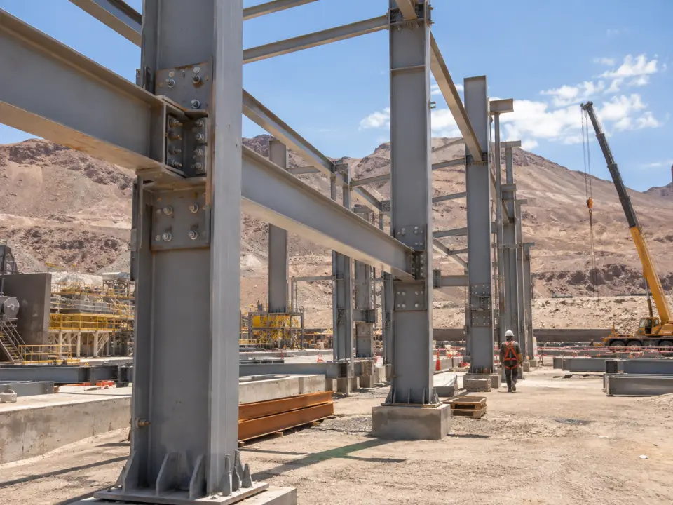 Estructura de acero en montaje en un patio industrial del norte con una grúa al fondo